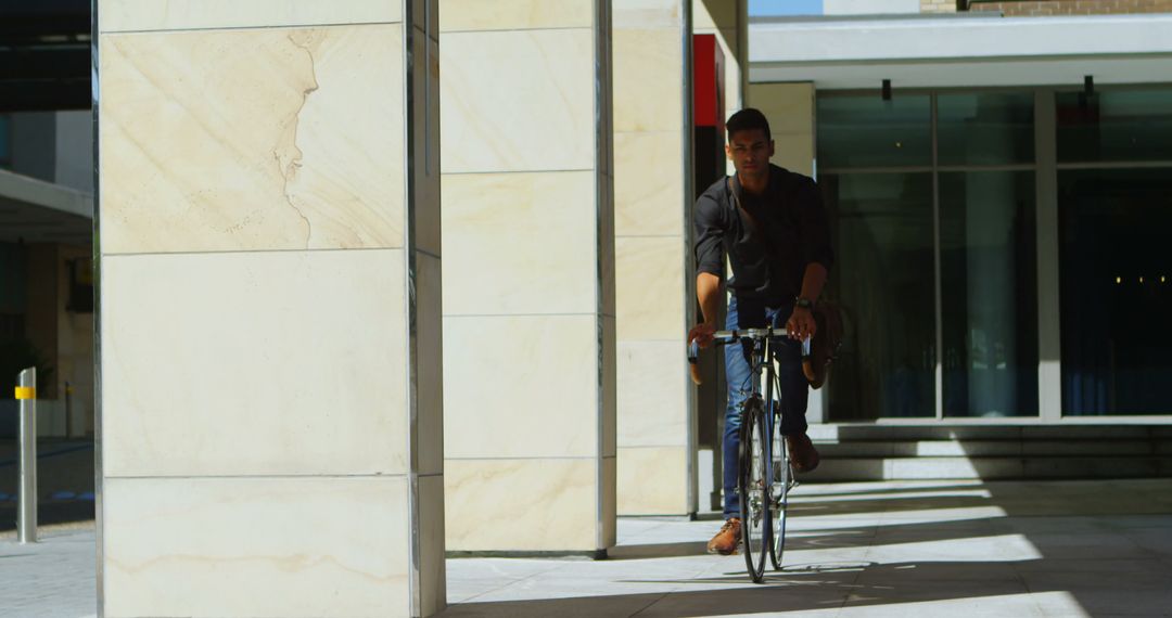 Urban Commuter Biking on Sunny Day Near Modern Buildings - Free Images, Stock Photos and Pictures on Pikwizard.com