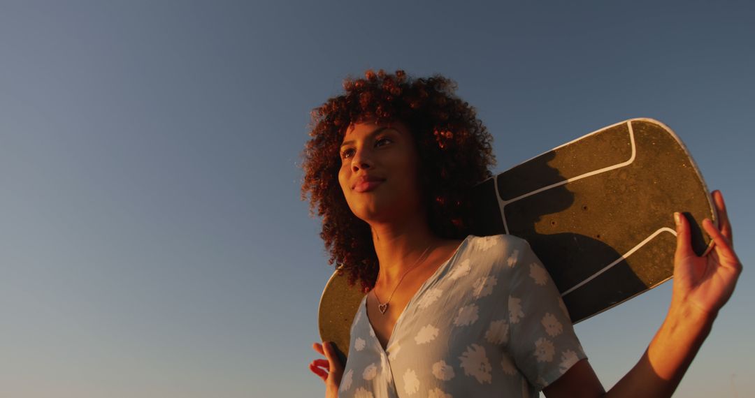 Young Woman Carries Skateboard at Sunset - Free Images, Stock Photos and Pictures on Pikwizard.com