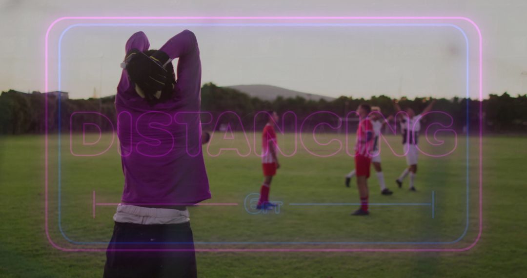 Spectator Overlooks Soccer Game with Distancing Reminder Overlay