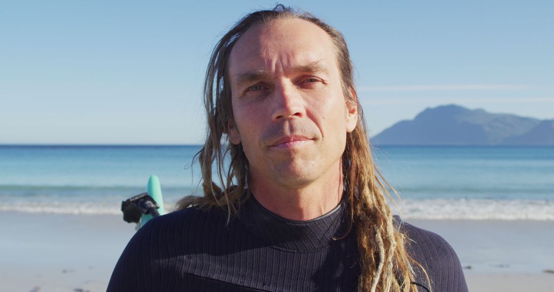 Surfer with Long Dreadlocks on Sunny Beach Looking at Camera - Free Images, Stock Photos and Pictures on Pikwizard.com