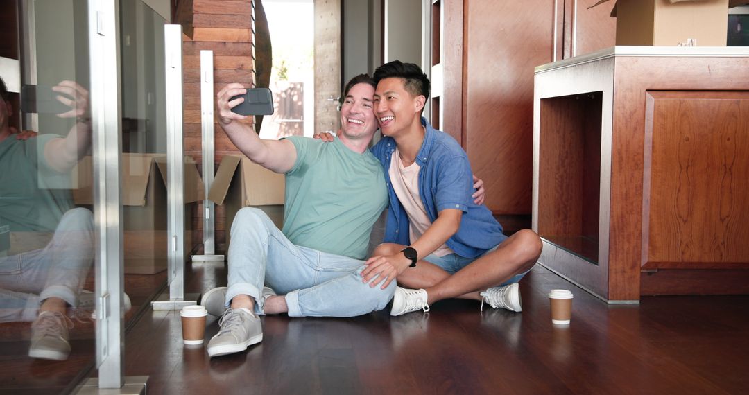 Diverse Couple Enjoying Moment at New Home with Smartphone