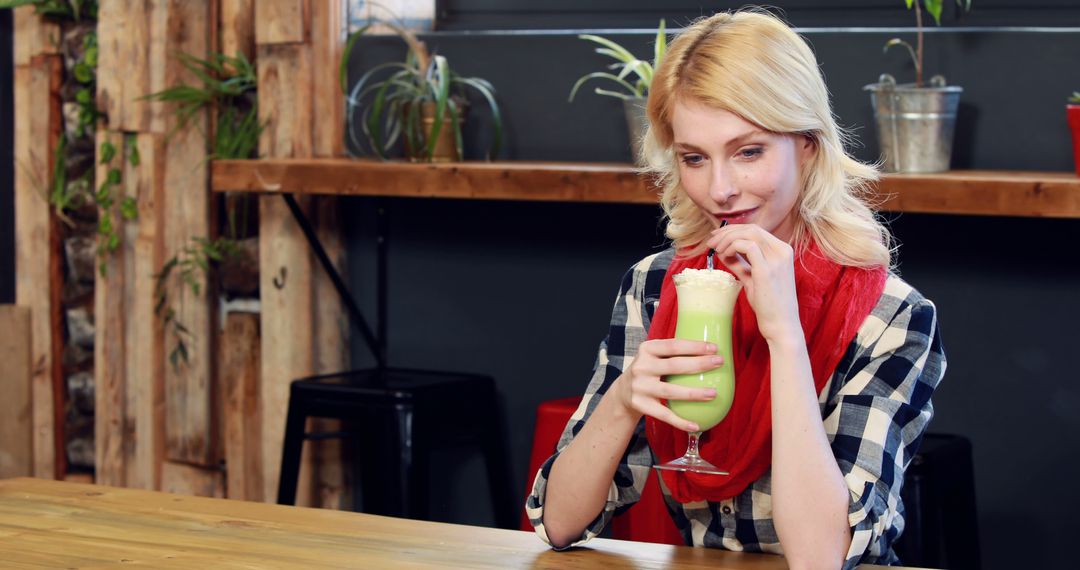 Woman Drinking Green Smoothie in Plant-Filled Café - Free Images, Stock Photos and Pictures on Pikwizard.com