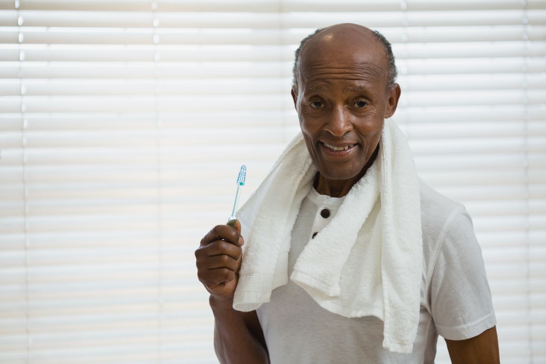 Senior Man Holding Toothbrush in Bathroom - Free Images, Stock Photos and Pictures on Pikwizard.com