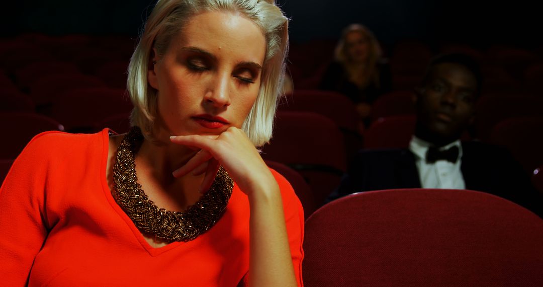 A bored woman contrasts with an engaged man at a theater event. - Free Images, Stock Photos and Pictures on Pikwizard.com