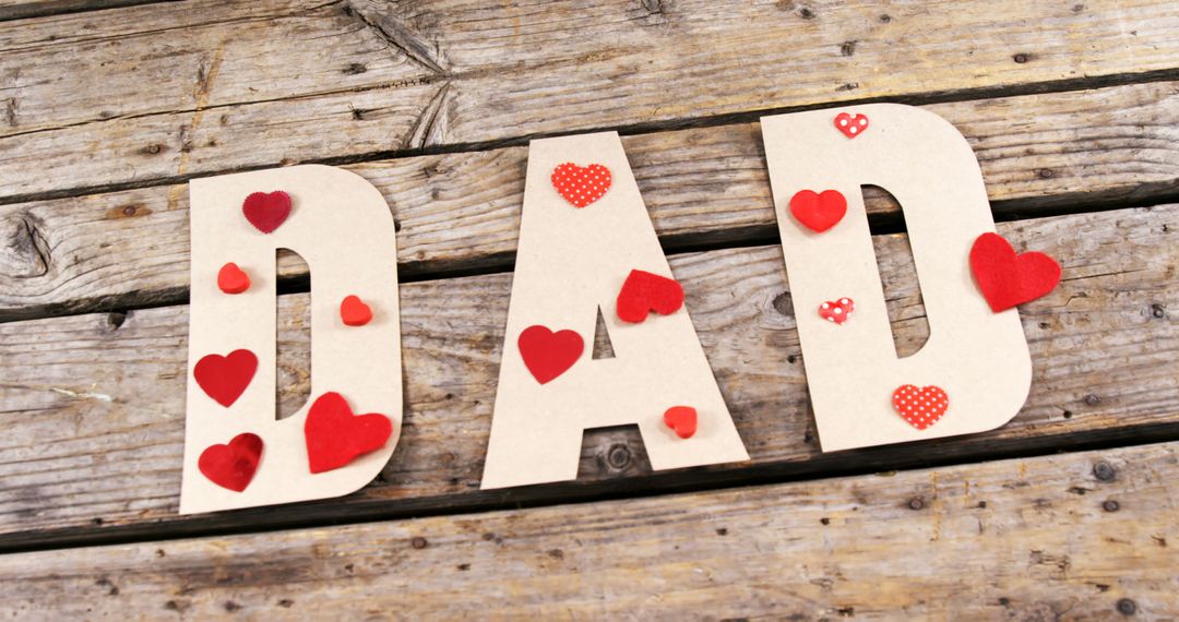 Cardboard Letters Spelling DAD with Red Hearts on Wooden Background - Free Images, Stock Photos and Pictures on Pikwizard.com