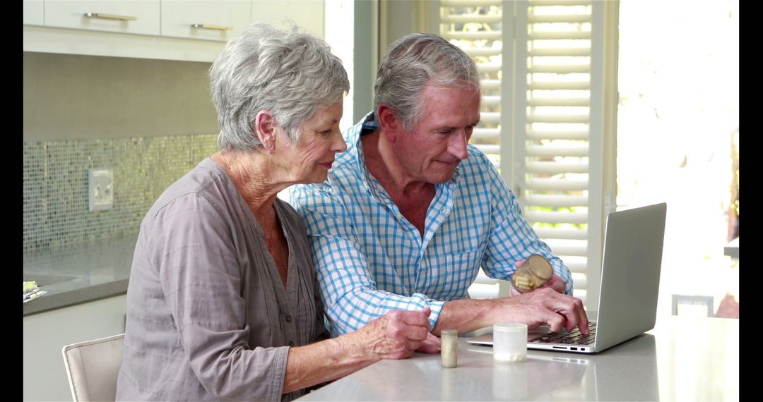 Senior Couple Using Laptop for Online Shopping in Modern Kitchen - Free Images, Stock Photos and Pictures on Pikwizard.com
