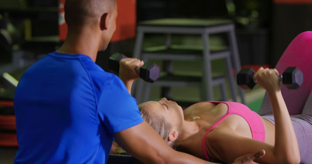 Personal Trainer Assisting Woman with Dumbbell Exercise in Gym - Free Images, Stock Photos and Pictures on Pikwizard.com