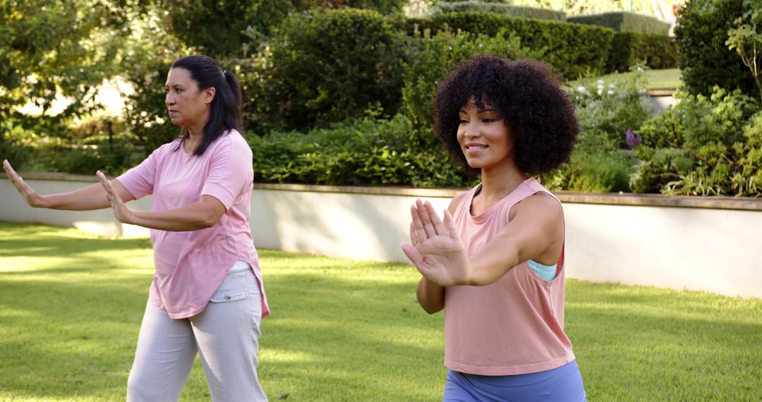 Mother and Daughter Practicing Tai Chi Together in Park