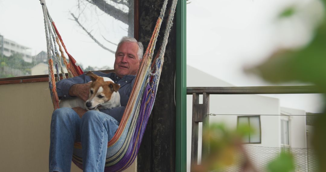 Senior Man Relaxing in Hammock with Dog on Balcony - Free Images, Stock Photos and Pictures on Pikwizard.com