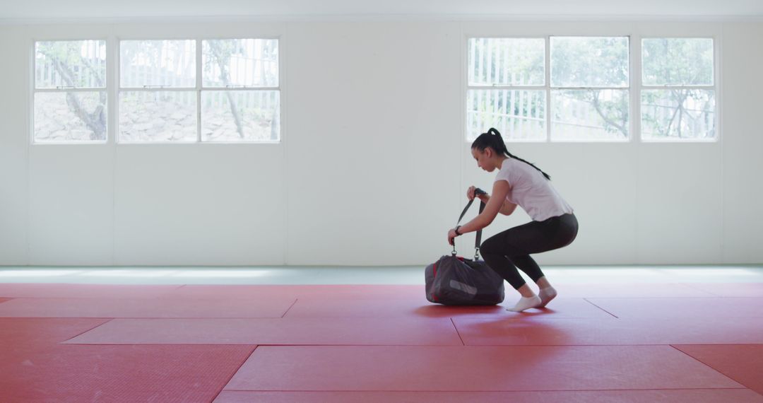 Woman Preparing for Martial Arts Training in Empty Studio - Free Images, Stock Photos and Pictures on Pikwizard.com