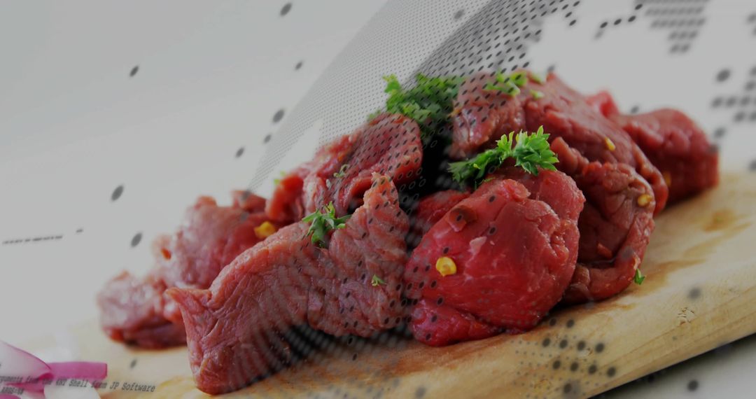 Raw Beef Chunks with Parsley and Cracked Pepper on Cutting Board