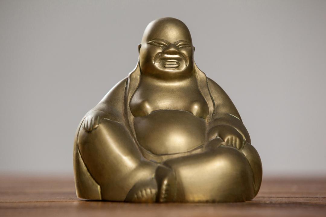 Gold Laughing Buddha Figurine on Wooden Table - Free Images, Stock Photos and Pictures on Pikwizard.com