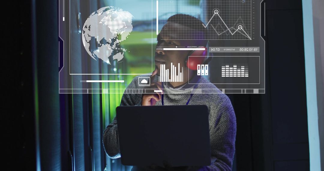 Biracial Man Using Laptop for Data Processing in Server Room