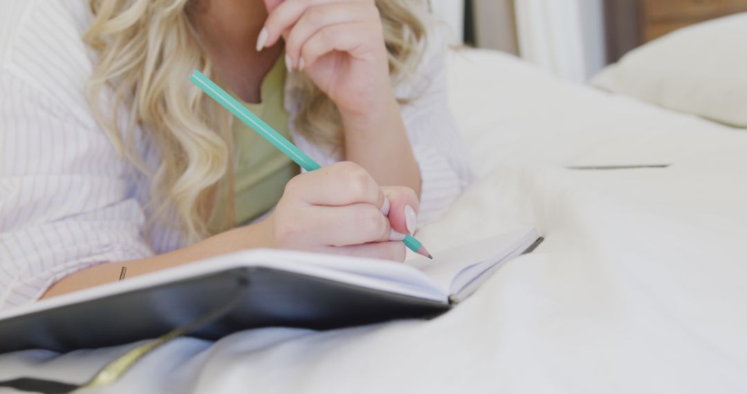 Woman Journaling on Bed with a Pencil - Free Images, Stock Photos and Pictures on Pikwizard.com