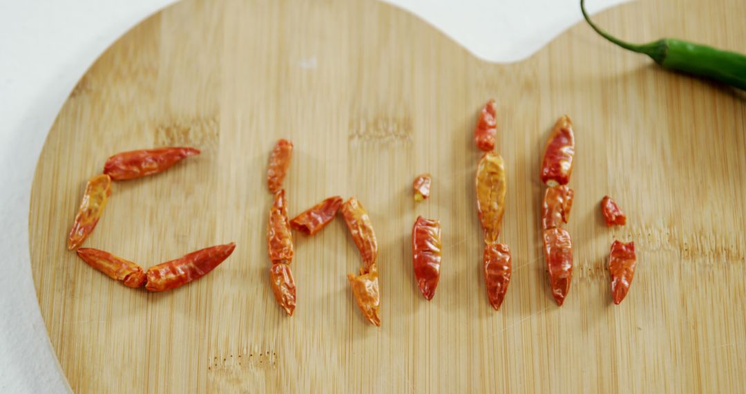 A wooden board spells CHILI with dried red peppers, highlighting the spice's essence. - Free Images, Stock Photos and Pictures on Pikwizard.com