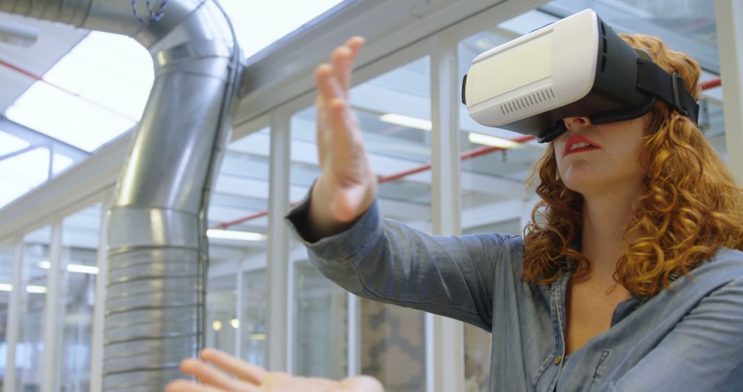 Woman Engaging with Virtual Reality in Modern Office - Free Images, Stock Photos and Pictures on Pikwizard.com