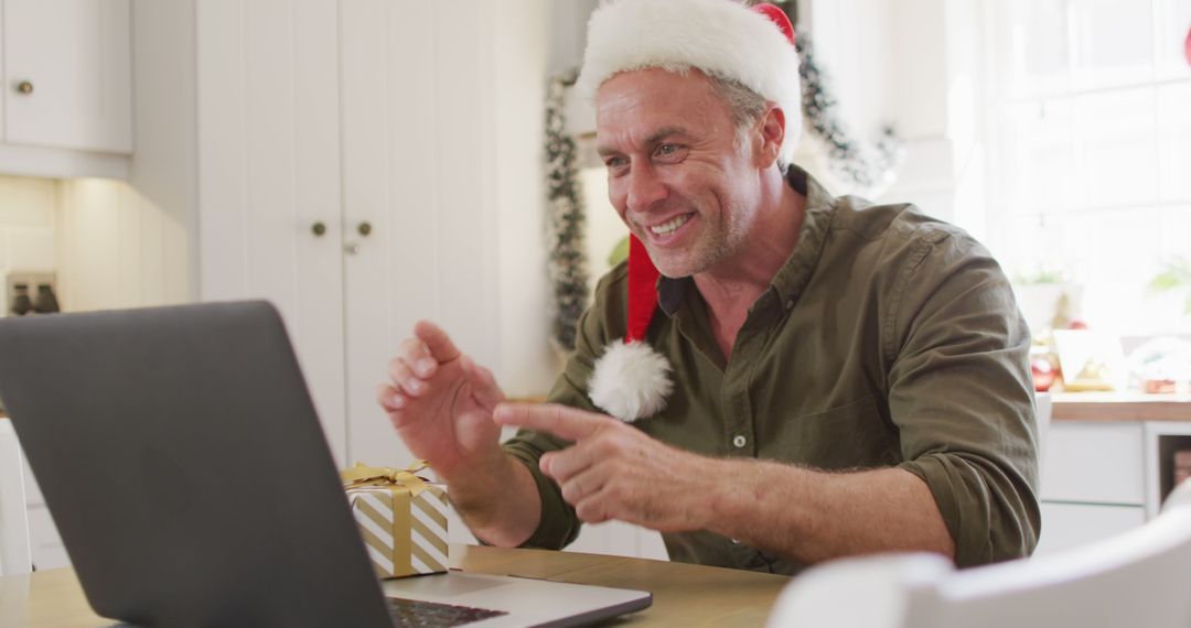 Man Wearing Santa Hat Video Calling Family During Christmas - Free Images, Stock Photos and Pictures on Pikwizard.com