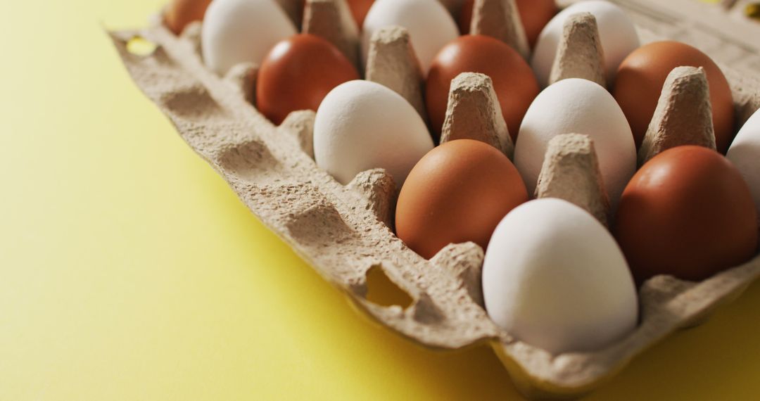 Image of eggs in packaging box on a yellow surface - Free Images, Stock Photos and Pictures on Pikwizard.com