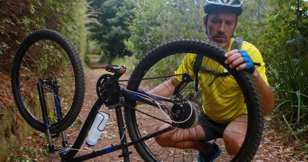 Man Repairing Bicycle Tire on Forest Trail During Mountain Bike Ride - Free Images, Stock Photos and Pictures on Pikwizard.com