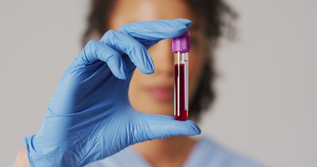 Image of biracial female doctor holding test tube on blue background - Free Images, Stock Photos and Pictures on Pikwizard.com
