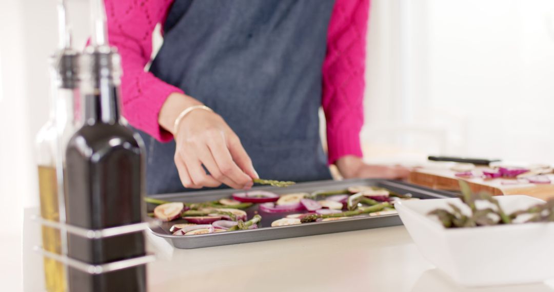 Person in Apron Preparing Roasted Vegetables on Baking Sheet - Free Images, Stock Photos and Pictures on Pikwizard.com