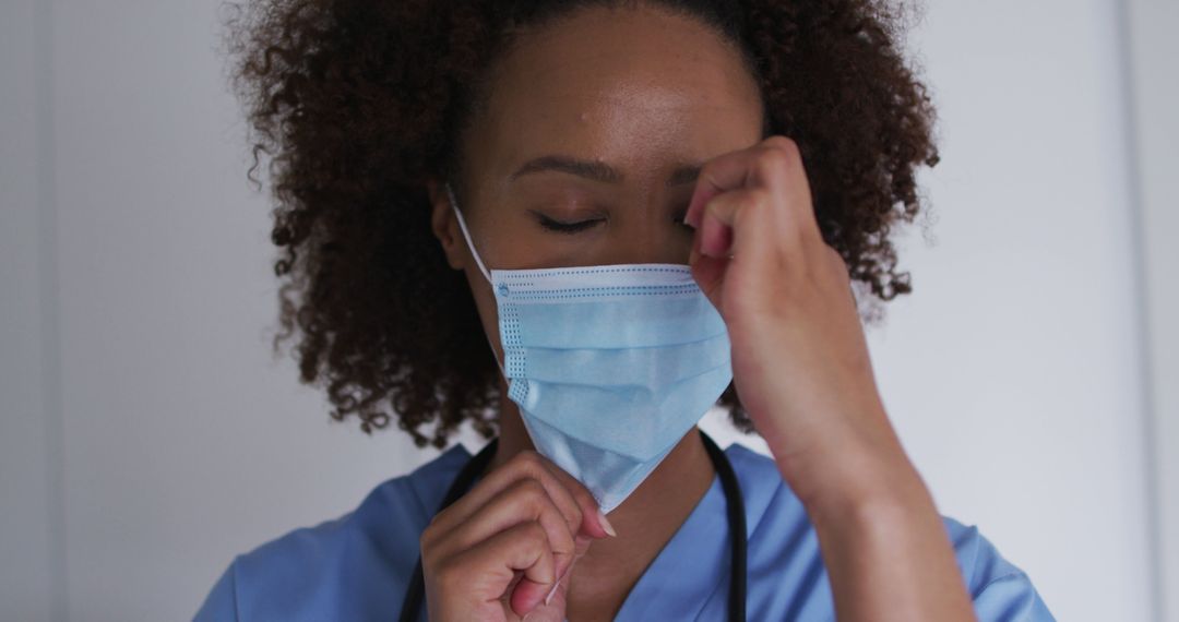 Tired Healthcare Worker Removing Face Mask After Shift - Free Images, Stock Photos and Pictures on Pikwizard.com