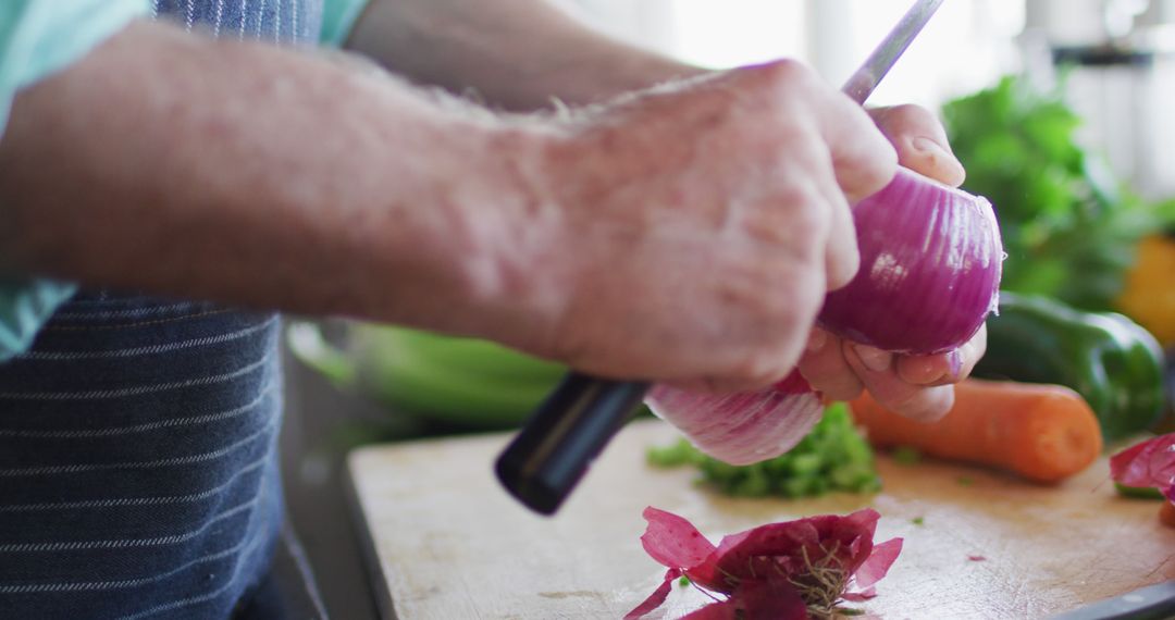 Close-Up of Senior Man Peeling Red Onion in Home Kitchen - Free Images, Stock Photos and Pictures on Pikwizard.com