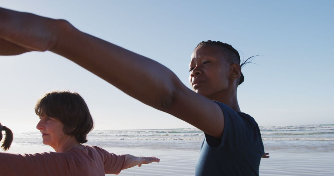 Two women practicing yoga on beach at sunrise - Free Images, Stock Photos and Pictures on Pikwizard.com