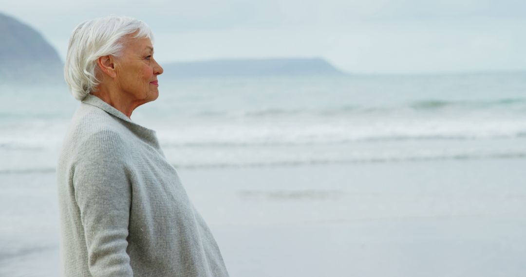 Senior Woman Contemplating by the Ocean at Beach - Free Images, Stock Photos and Pictures on Pikwizard.com