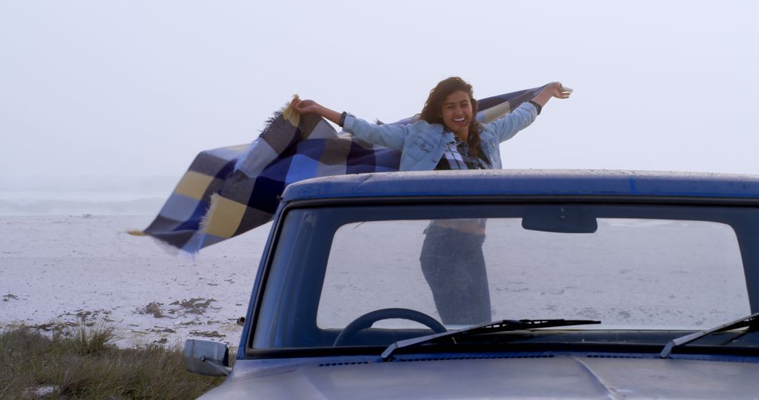 Cheerful Young Woman Enjoying Beach Road Trip with Blanket - Free Images, Stock Photos and Pictures on Pikwizard.com