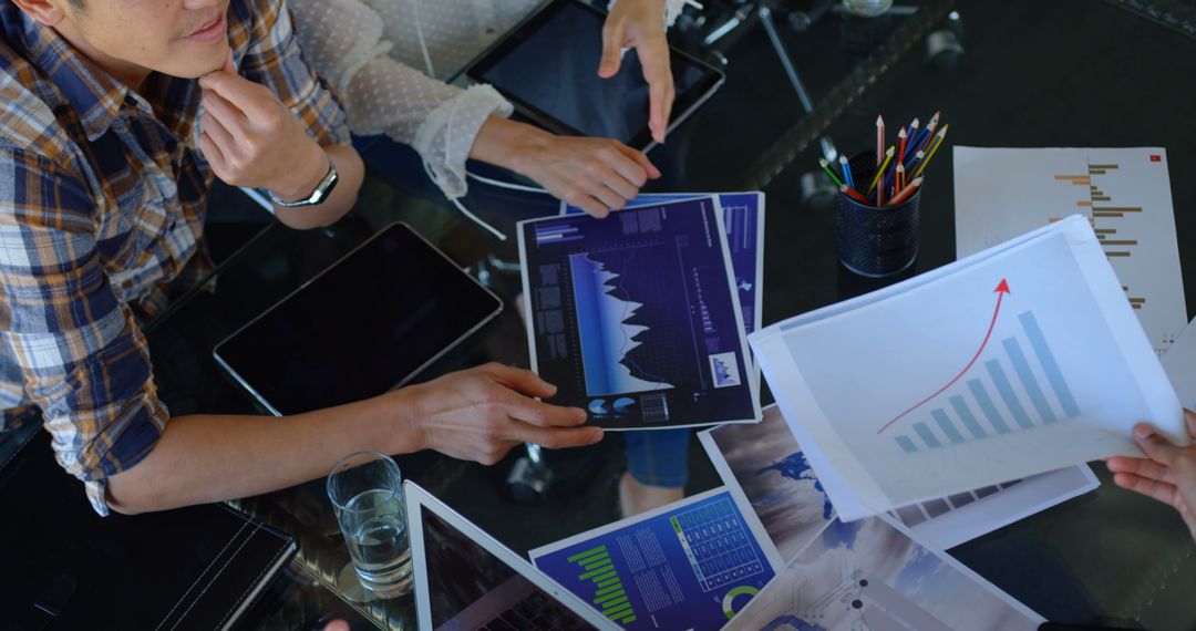 Diverse Business Team Analyzing Graphs at Office Table