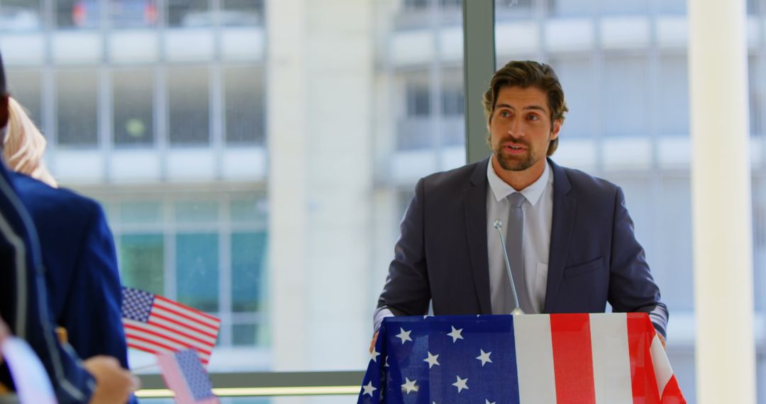 Business Seminar Speaker Addressing Enthusiastic Audience with American Flags