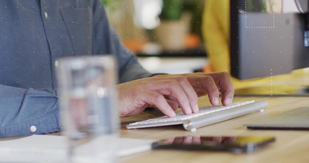 Hands typing on wireless keyboard at modern office desk boosting productivity and focus