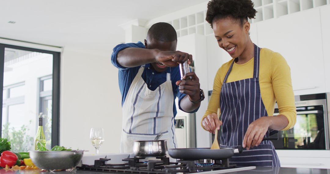 Image of happy african american couple cooking together - Free Images, Stock Photos and Pictures on Pikwizard.com