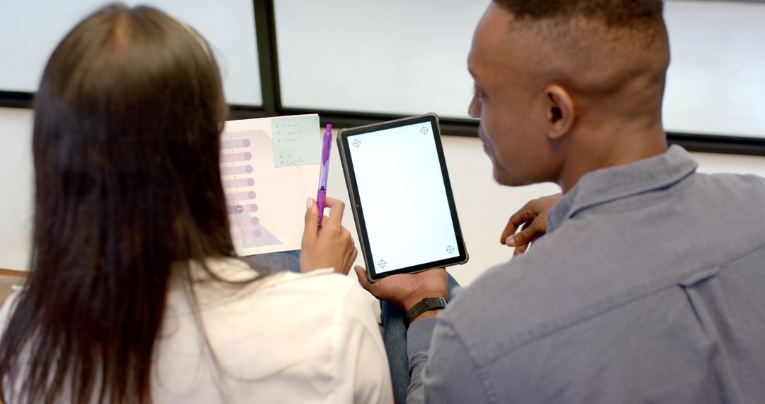 Colleagues Collaborating on Project Using Tablet in Office Setting