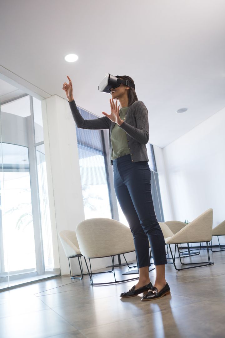 Businesswoman Interacting with Virtual Reality in Modern Office - Free Images, Stock Photos and Pictures on Pikwizard.com