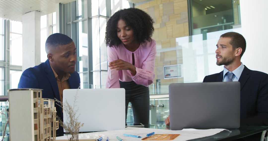 Team Collaboration at Office with Laptops and Project Materials