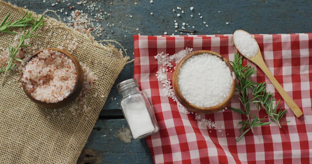 Gourmet Salt Varieties with Rosemary on Rustic Tabletop