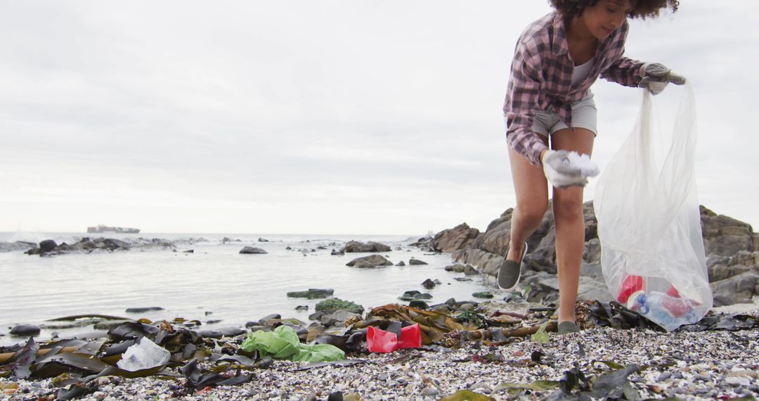 Woman Cleaning Beach of Plastic Pollution on Cloudy Day - Free Images, Stock Photos and Pictures on Pikwizard.com