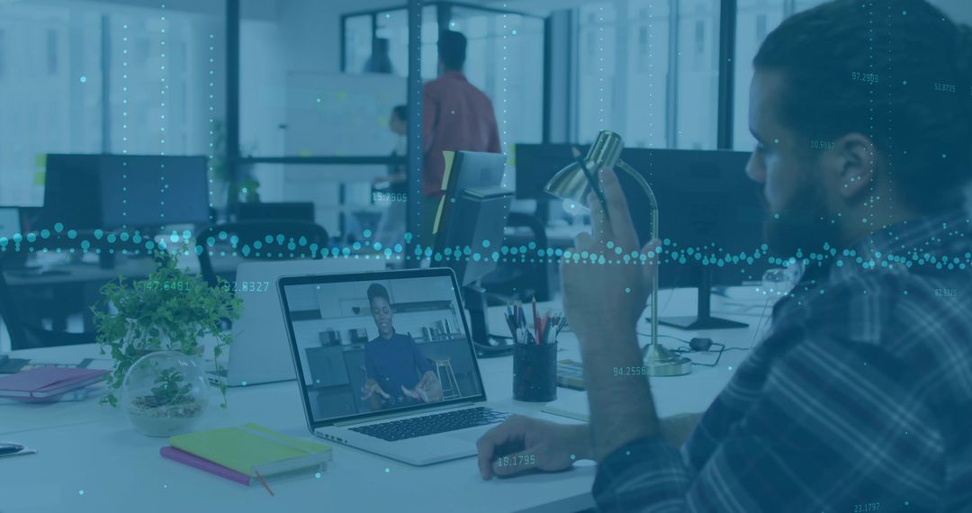 Working man with bun holding lamp attending video call at shared office with analytics overlay