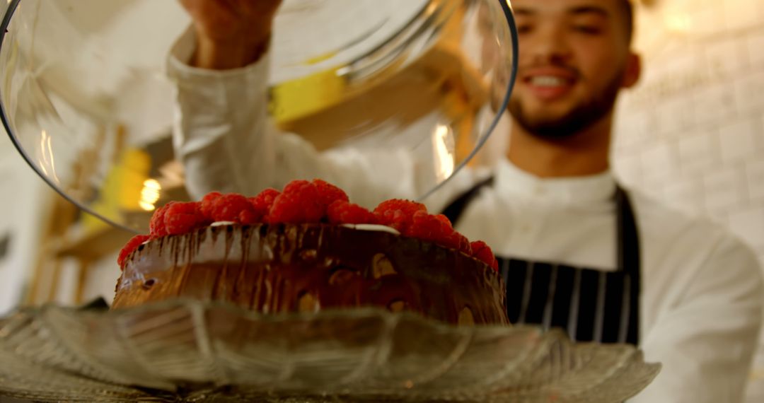 Baker Adding Glass Dome to Raspberry Chocolate Cake - Free Images, Stock Photos and Pictures on Pikwizard.com