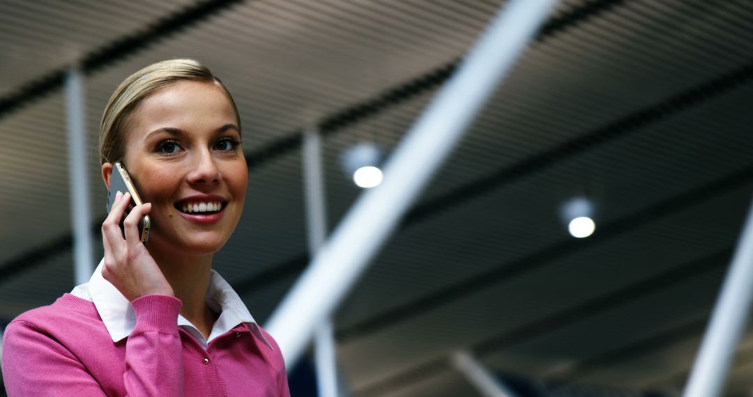 Smiling Professional Woman on Mobile Phone at Airport Terminal