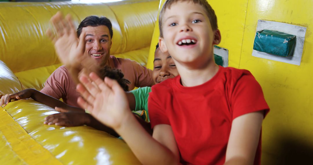 Happy Children Playing on Inflatable Obstacle Course with Smiling Adult - Free Images, Stock Photos and Pictures on Pikwizard.com