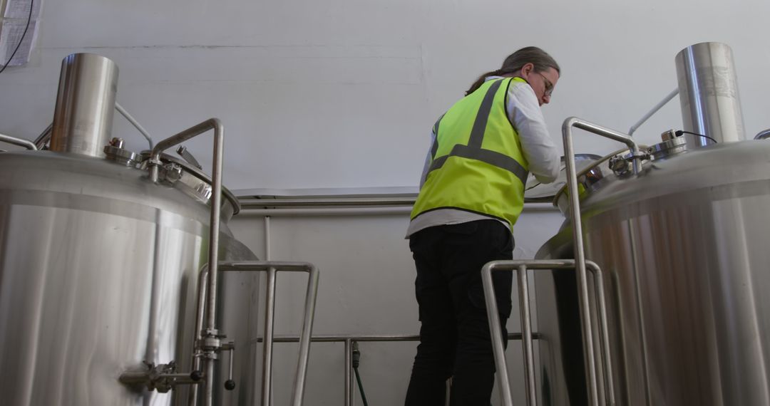 Worker Inspecting Industrial Brewing Equipment in Modern Brewery - Free Images, Stock Photos and Pictures on Pikwizard.com