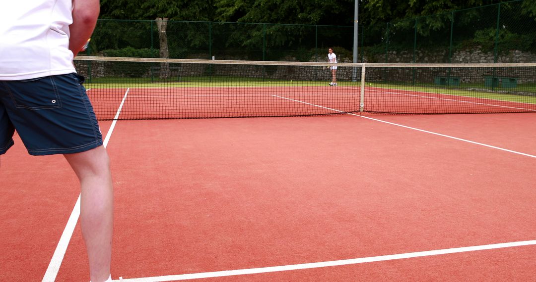 Two People Playing Tennis on Outdoor Court - Free Images, Stock Photos and Pictures on Pikwizard.com