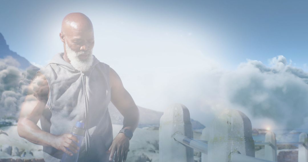 Fit Senior Man Exercising with Hydration Under Majestic Clouds