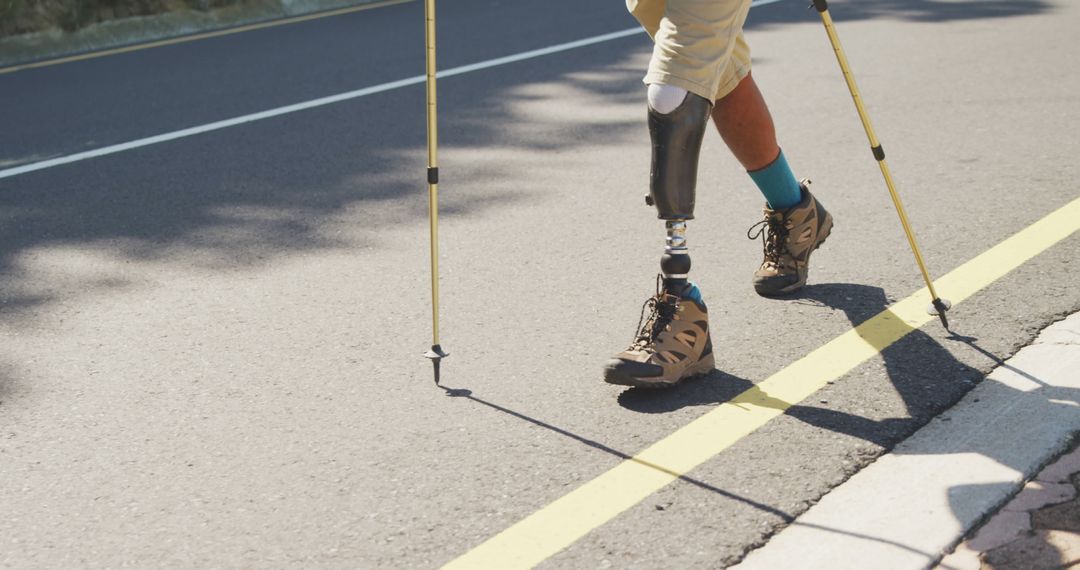 Person with Prosthetic Leg Hiking on Road with Trekking Poles - Free Images, Stock Photos and Pictures on Pikwizard.com