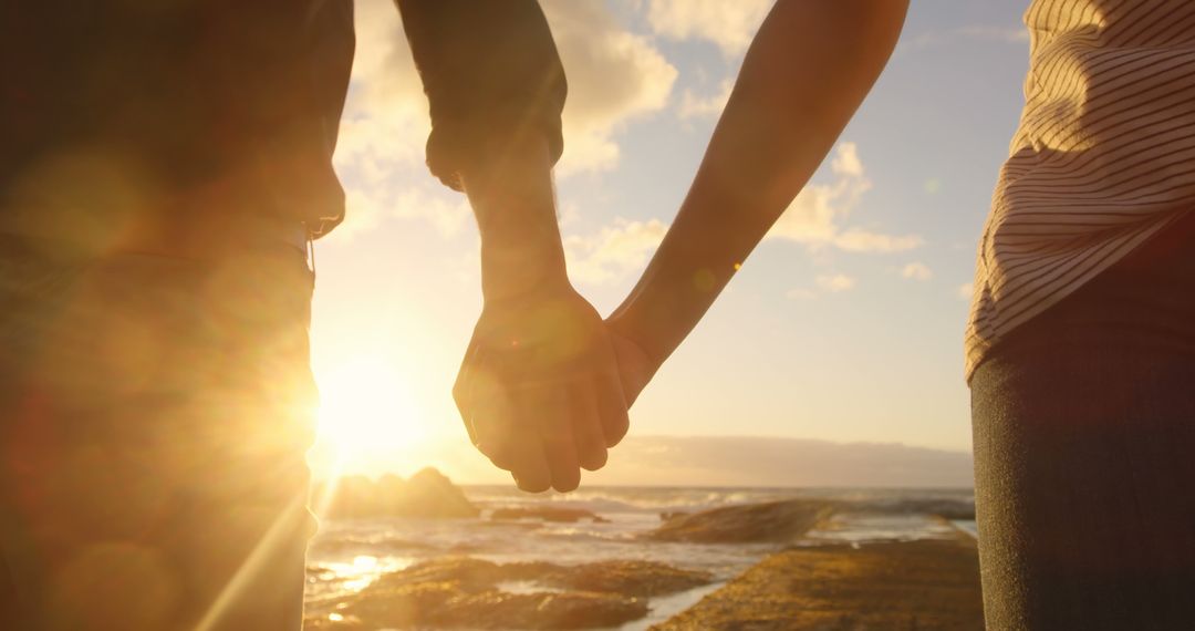 Diverse couple holding hands at sunset, with copy space - Free Images, Stock Photos and Pictures on Pikwizard.com