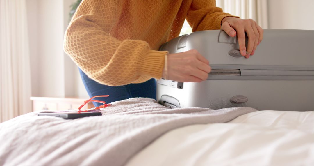 Person Packing Suitcase on Bed in Bright Bedroom - Free Images, Stock Photos and Pictures on Pikwizard.com