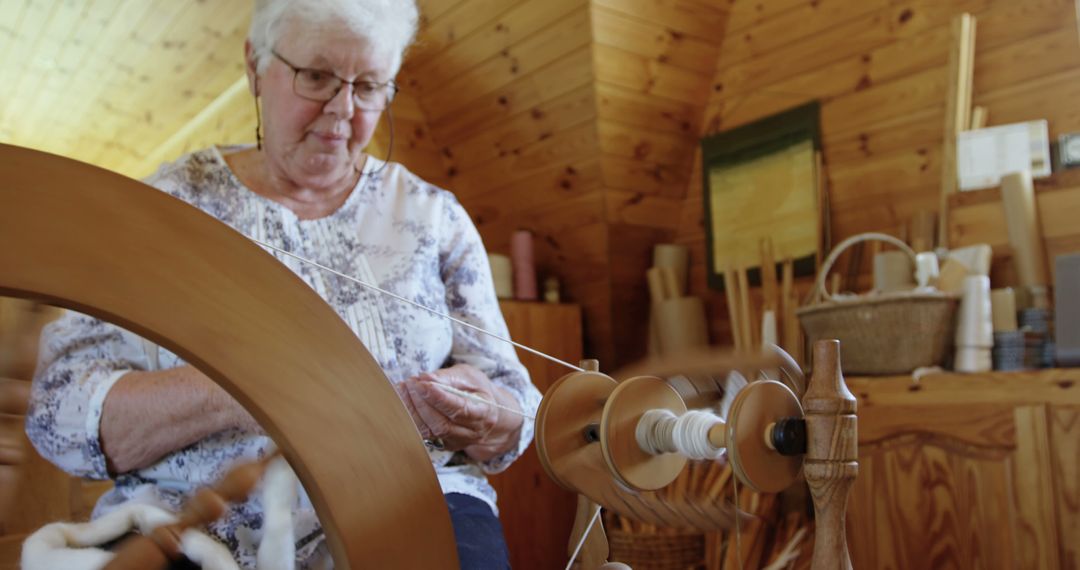 Elderly Woman Using Spinning Wheel for Traditional Yarn Making - Free Images, Stock Photos and Pictures on Pikwizard.com